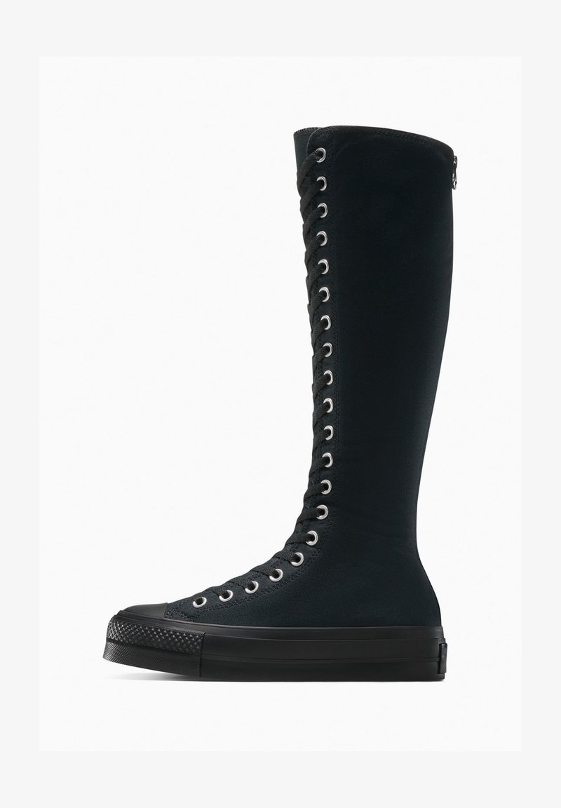 Bottes hautes noires en tissu texturé avec un design à lacets, œillets en argent, semelle en caoutchouc noire et embout lisse.