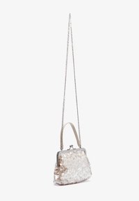 Pailletten-Handtasche mit einem silberfarbenen Metallrahmen, ausgestattet mit einem Kettenriemen und einem cremefarbenen Griff. Strukturierte Oberfläche mit runden Pailletten.
