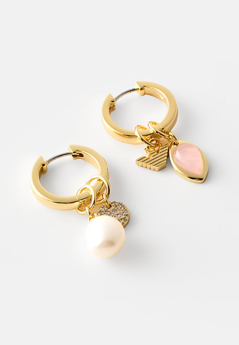 Złote kolczyki w kształcie kół z zawieszkami: duża perła, lśniący dysk, różowy łezkowaty element oraz teksturowany trójkątny akcent.