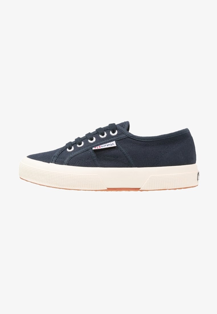 Baskets basses en toile noire avec semelle en caoutchouc blanche, lacets à l'avant et petite étiquette de la marque Superga sur le côté.