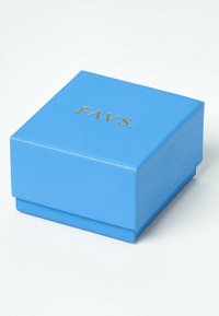 Boîte carrée bleue avec le texte doré en relief "FAVS." sur le couvercle, posée sur une surface blanche.