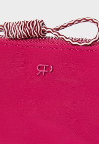 Pink leather bag featuring a textured surface, a zipper closure, and a decorative multicolored cord accent at the top. Logo embossed on side.