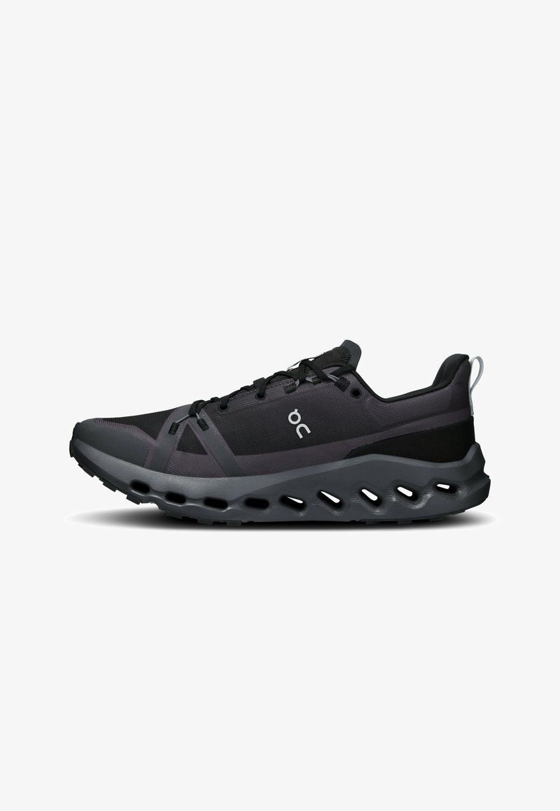 Black athletic shoe featuring mesh and synthetic materials, curved sole with cutouts, textured lacing system, and branding on the side.
