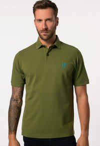 Polo de color verde oliva con cuello, mangas cortas y un pequeño logo azul "JP" en el pecho. La tela parece texturizada y ajustada.