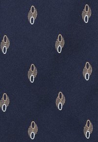 Granatowa tkanina o teksturowanej powierzchni, z powtarzającym się wzorem małych kremowo-białych motywów w kształcie owalnych.