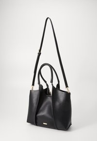 Schwarze Leder-Tote mit strukturierter Oberfläche, doppelten Griffen und einem abnehmbaren Schulterriemen. Goldfarbene Hardware-Akzente und Reißverschlussdetails.