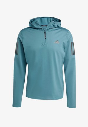 Felpa a maniche lunghe blu chiaro realizzata in un tessuto liscio e strutturato. Presenta una chiusura frontale con mezza zip, un cappuccio e tre strisce scure su ogni manica.
