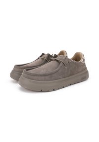 Chaussures en daim gris avec une semelle en caoutchouc épaisse et texturée. Présentent un design à lacets et un accent à motif à l'arrière.