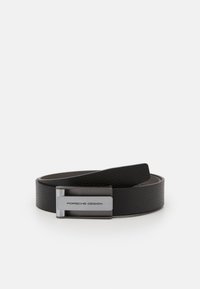 Cinturón de cuero negro con un acabado texturizado, que presenta una hebilla rectangular de plata grabada con "PORSCHE DESIGN". Forro interior suave.