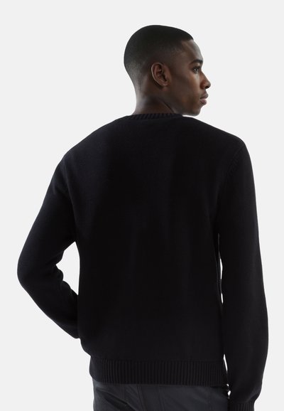 Suéter negro de punto con cuello redondo, puños y dobladillo acanalados, que presenta una textura suave y un diseño ajustado. Detalles de costura visibles.