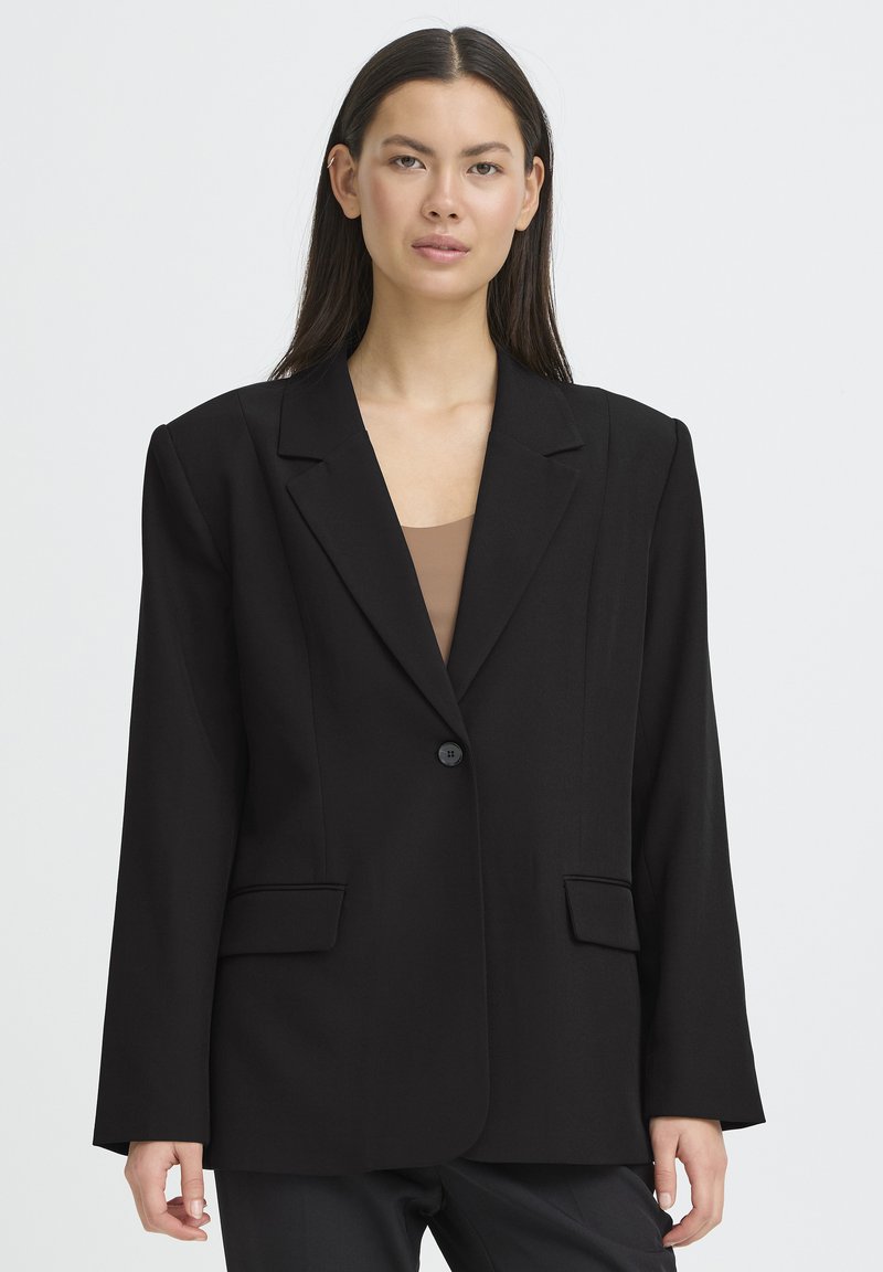 Blazer noir cintré avec une fermeture à un bouton, de larges revers et deux poches avant ; fabriqué en tissu structuré à texture lisse.