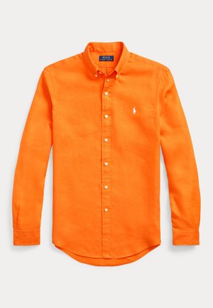 Chemise orange vif à manches longues, boutonnée, avec col boutonné et petit logo blanc brodé sur la poitrine gauche.