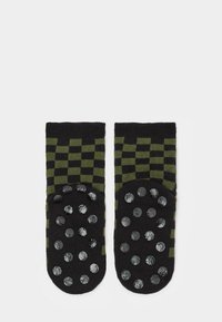 Schwarz-grüne karierte Socken mit Gummigriffen an der Unterseite für Grip. Strickstoff, gerippter Bund und kontrastierende Texturen.