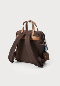 Zaino in nylon marrone con accenti in pelle, due spallacci e un dettaglio a portachiavi. Presenta una chiusura con zip e una tasca frontale aggiuntiva.