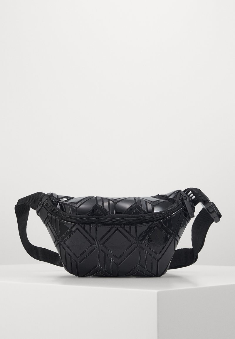 Zwarte crossbodytas van textuur synthetisch materiaal. Voorzien van een geometrisch patroon en een ritssluiting. Verstelbare stoffen schouderband bevestigd.