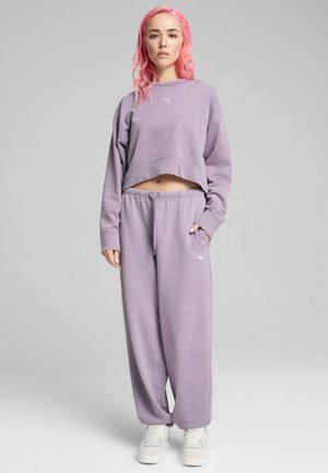 Felpa cropped viola con maniche lunghe e abbinamento di pantaloni della tuta. Tessuto morbido con vita elastica e dettagli del logo sulla coscia sinistra.