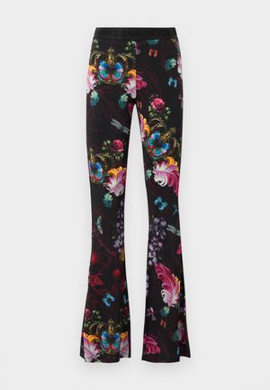 Pantalons évasés en tissu extensible avec un arrière-plan noir, arborant de vibrants motifs floraux et de papillons, ainsi qu'une ceinture décorative.
