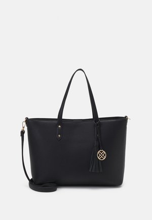 Black leather tote bag with textured surface, two handles, gold hardware, tassel accent, and a detachable shoulder strap.