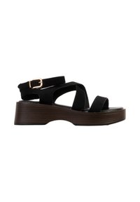 Sandale à plateforme noire avec semelle en bois, bout ouvert, brides croisées et bride de cheville avec boucle dorée.