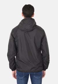 Giubbotto leggero nero con cappuccio, polsini elastici e una texture liscia, caratterizzato da un design semplice senza loghi o pattern visibili.