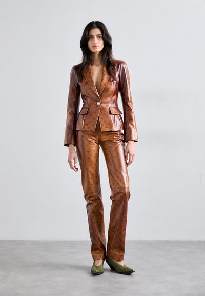 Costum din piele format dintr-o jachetă maro căptușită și pantaloni asortați, având o textură subtilă cu model și un închidere cu un singur buton.