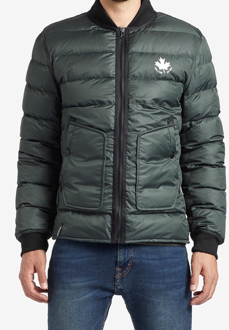 Zateplená bomber bunda ve tmavě zelené barvě, s předním zipem, dvěma náprsními kapsami a černým ribbed límcem. Logo na hrudi.