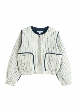 Cream quilted jacket with navy diamond stitching, zip front, two large front pockets, elastic cuffs, and navy trim on collar and pockets.