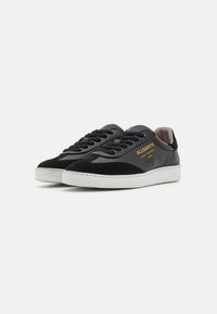 Sneaker nere in pelle con dettagli in camoscio, suole spesse in gomma bianca, punta rotonda e lacci neri. Logo "ALLSAINTS" in oro sui lati.