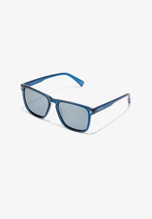 Gafas de sol azules con montura rectangular, lentes grises y un acabado brillante. Cuenta con patas de color azul texturizadas y un logo de la marca en el lateral.