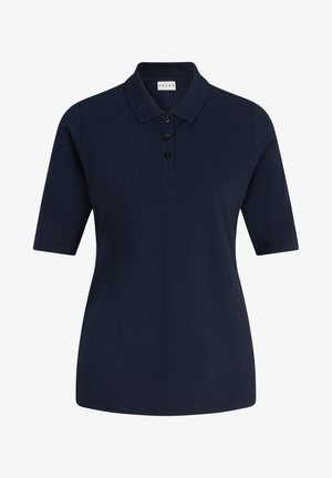 Marineblauwe polo met een kraag en drie knopen, gecombineerd met lichtgrijze joggingbroeken en witte sneakers met elastische manchetten.