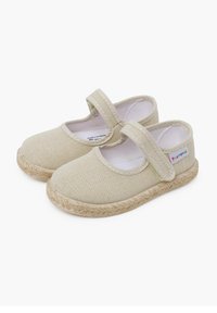 Beige lærredssko med rund tå, velcro-rem og vævet jute-sål. Glat tekstur med minimal syning.
