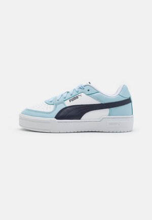 Low-top Puma sneaker i hvid, lyseblå og marineblå med snørelukning, polstret krave og tyk hvid sål, sideprofil.