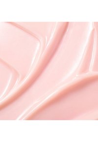 Glatter, glänzender, blassrosafarbener Creme- oder Lotionstextur mit fließenden, geschwungenen Texturen und reflektierenden Highlights auf einer ebenen Oberfläche.