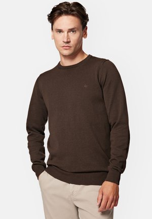 Brązowy sweter dzianinowy z okrągłym dekoltem, ściągaczami przy mankietach i u dołu, oraz subtelnym detalem logo na klatce piersiowej. Gładka faktura i klasyczny krój.
