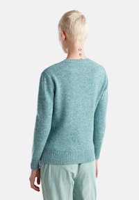 Maglione blu-verde realizzato in morbido tessuto testurizzato con orlo e polsini a costine; presenta un classico scollo a giro e un taglio dritto.