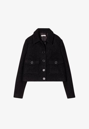 Veste cropped noire en tissu texturé, avec un col classique, des poches avant et une fermeture à boutons avec des boutons foncés.