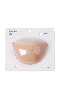 Backless bra in beige, made of soft fabric. Packaged with a clear front, showing curved cup shape. Includes size indicators on the label.