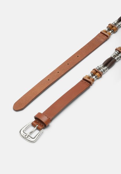 Barna bőrbőr öv ezüst csattal, és az övcsatonál valamint az övlyukaknál díszítő ezüst és fa gyöngyökkel, fehér háttéren.