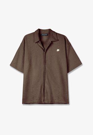 Brown short-sleeve button-up shirt with a textured fabric and a left chest logo. Features a classic collar and a relaxed fit.