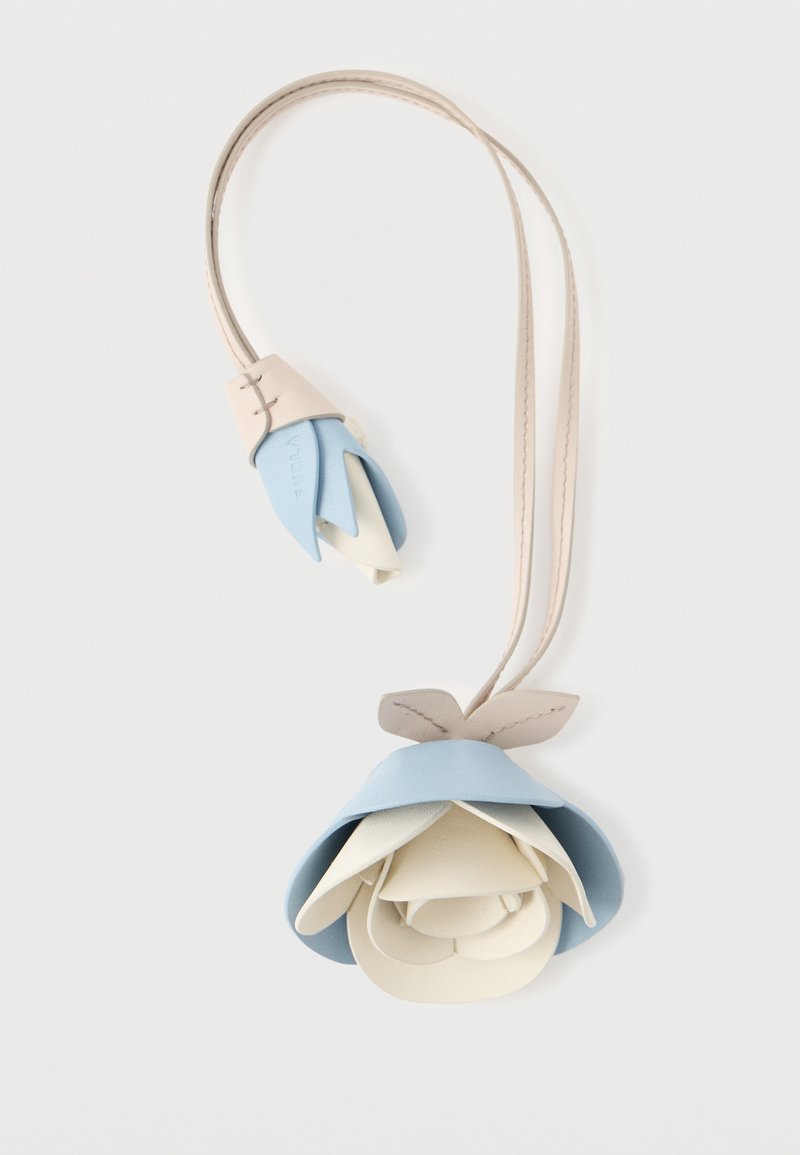 Pandantiv din piele în formă de floare, cu petale stratificate în albastru deschis, crem și bej, având o curea subțire și accente cusute.