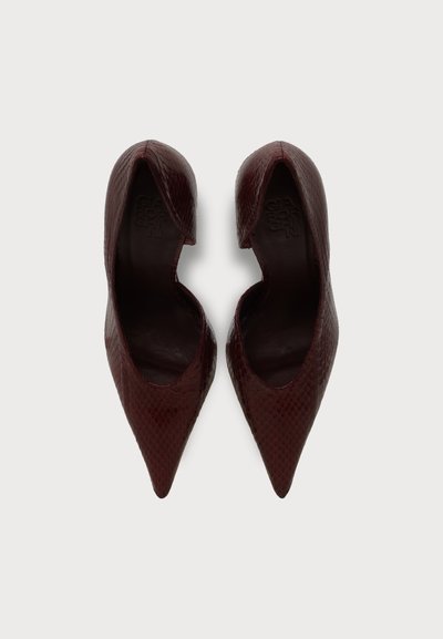 Paire d'escarpins marron foncé à bout pointu avec un motif texturé rappelant la peau de serpent, vues de dessus sur fond blanc.