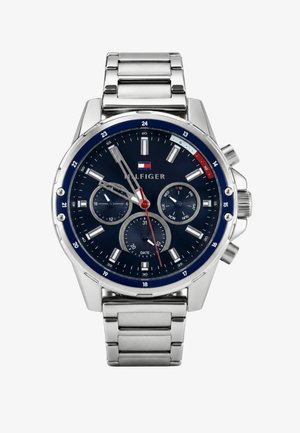 Orologio da polso in metallo argento con quadrante blu, tre sottoquadranti per 24 ore, giorno e data, e lancetta dei secondi rossa, che mostra l'ora 10:09:36.