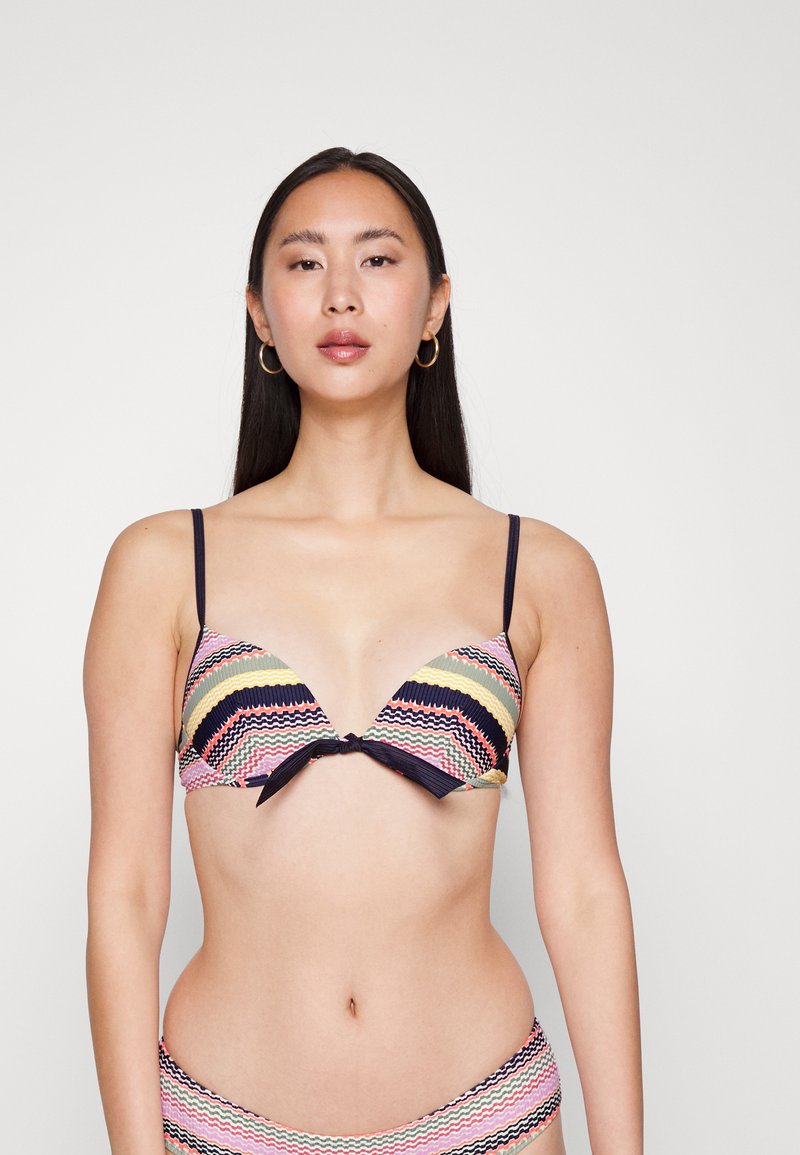 Top de biquíni multicolorido com um design em pontas, apresentando padrões em zig-zag nas cores rosa, azul marinho e amarelo, e um detalhe de laço na frente.