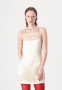 Satinová mini šaty v off-white farbe s tenkými ramienkami a priesvitnou panelou. Bočné akcenty sú s modrou linkou. Hladká textúra, priliehavý strih a minimalistický štýl.