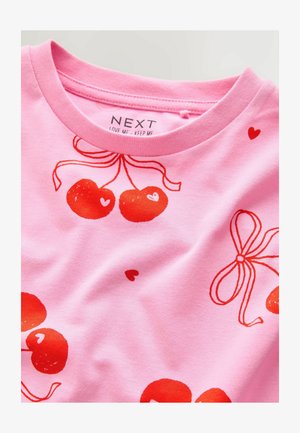 Maglietta rosa chiaro con una grafica di ciliegia rossa accompagnata da cuori e nastri. Realizzata in cotone morbido con un classico scollo a girocollo.