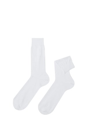 Chaussettes en coton blanc avec une texture lisse, dotées d'un design de longueur mi-mollet et d'une bordure côtelée. Une chaussette est repliée.
