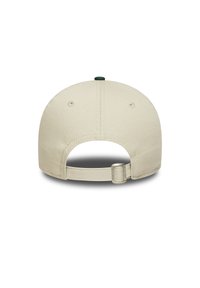 Gorra beige con una corona estructurada, material de tela, acento de botón verde en la parte superior y una correa ajustable en la parte trasera.