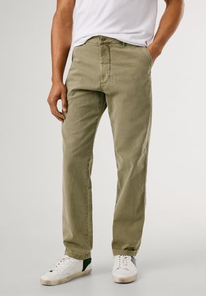 Olive green chinos with a straight fit, made from cotton fabric. Features front pockets and cuffed hems, paired with white sneakers.