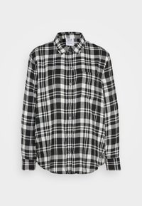 Camicia in flanella a quadri bianco e nero con colletto button-down, tasca frontale e maniche lunghe. Texture morbida e vestibilità rilassata.