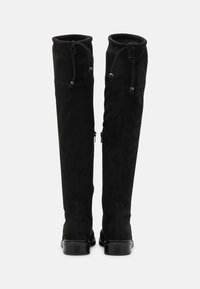 Botas negras de ante hasta la rodilla con acabado mate, que cuentan con un cordón en la parte superior y cremalleras laterales para facilitar su uso.